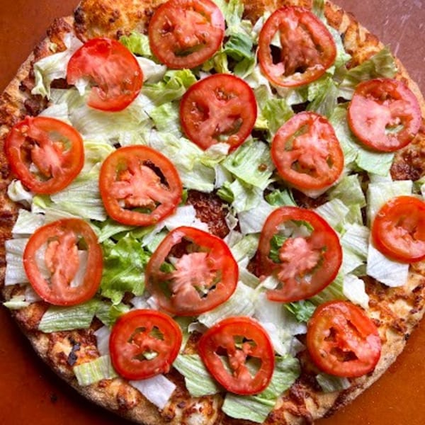 Detroit Pizza with a crispy crust, topped with fresh shredded lettuce and sliced red tomatoes.